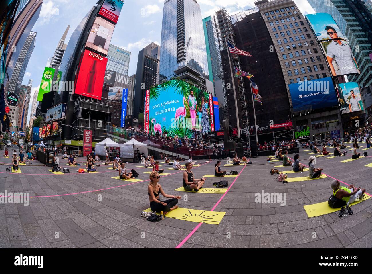 Sozial ferne Yogapraktiker packen den Times Square in New York ein, um am ersten Sommertag, Sonntag, 21. Juni 2021, Yoga zu praktizieren. Die jährliche Sonnenwende am Times Square, „Mind over Madness“, gesponsert von Ayrie, dem Generalkonsulat von Indien, New York und SmartWater, dehnt die Fähigkeit der Yogis aus, den Lärm und das visuelle Durcheinander, das sie an der Kreuzung der Welt umgibt, zu blockieren. Der erste Sommertag wurde von den Vereinten Nationen zum Internationalen Tag des Yoga erklärt. (ÂPhoto von Richard B. Levine) Stockfoto