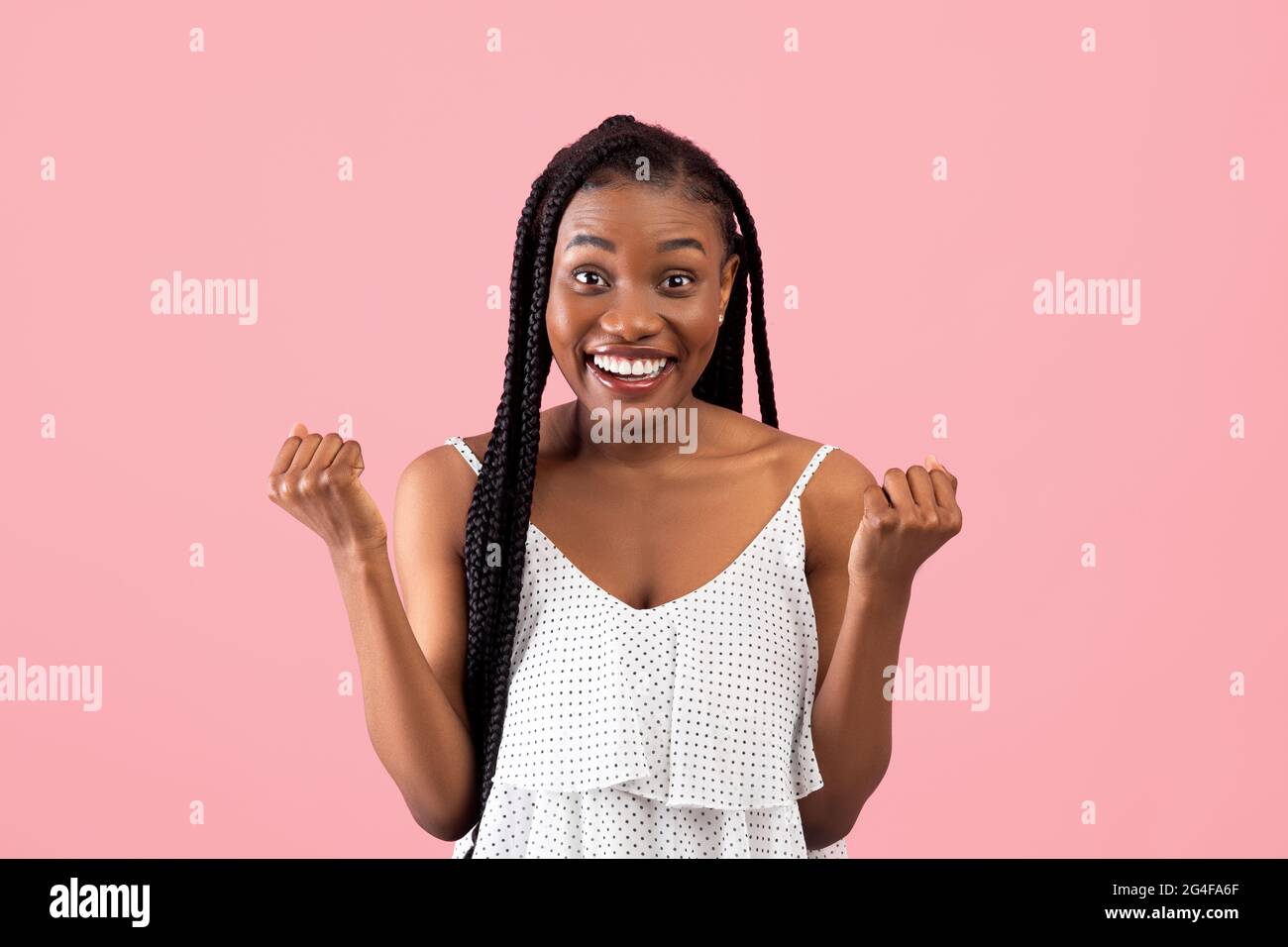 Aufgeregt schwarze Frau im Sommerkleid gestikulieren JA auf rosa Studio-Hintergrund Stockfoto
