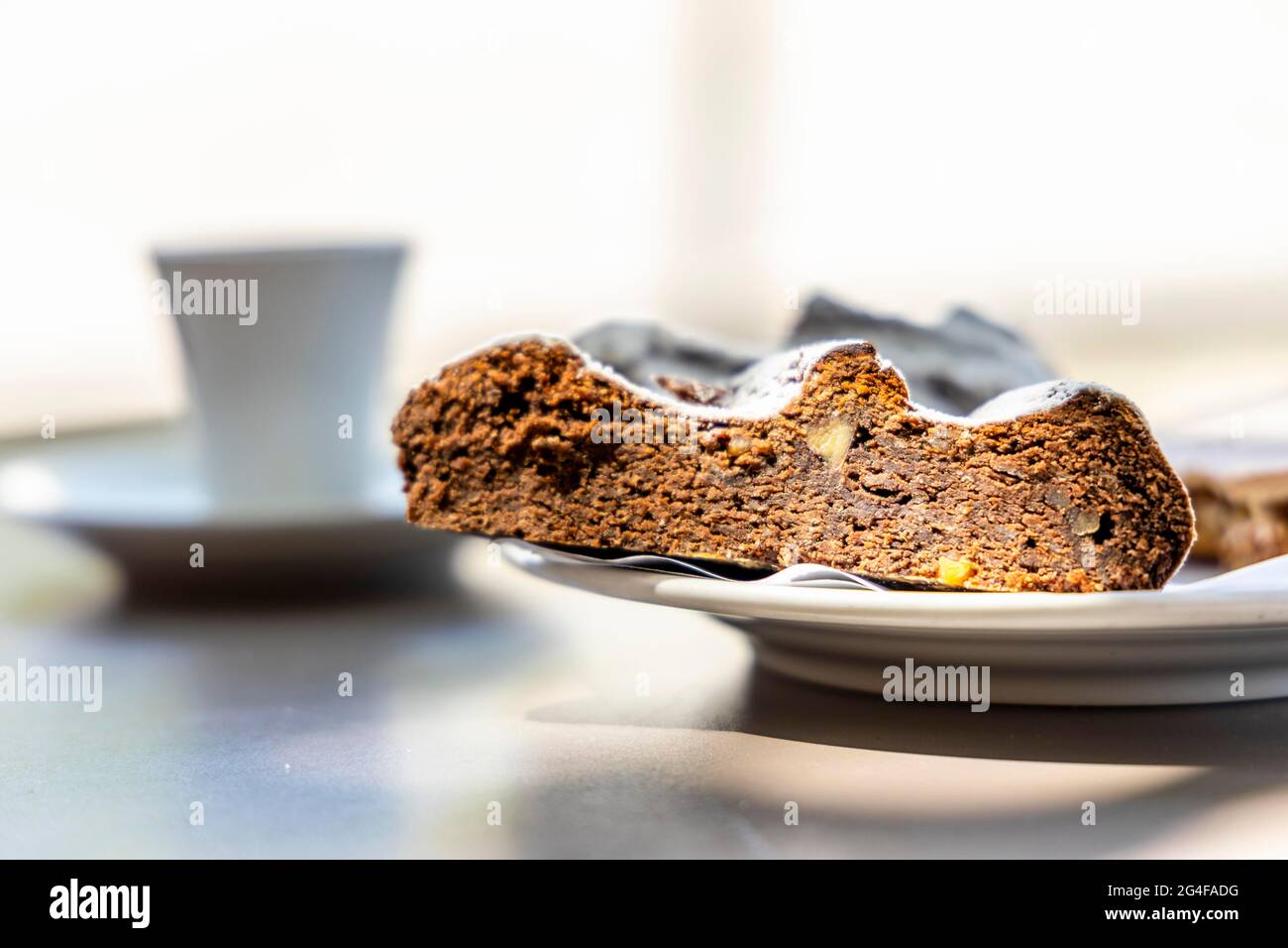 Portugiesisches Dessert aus Maismehl und Honig namens Broa de mel mit Kaffee im Hintergrund, Portugal Stockfoto