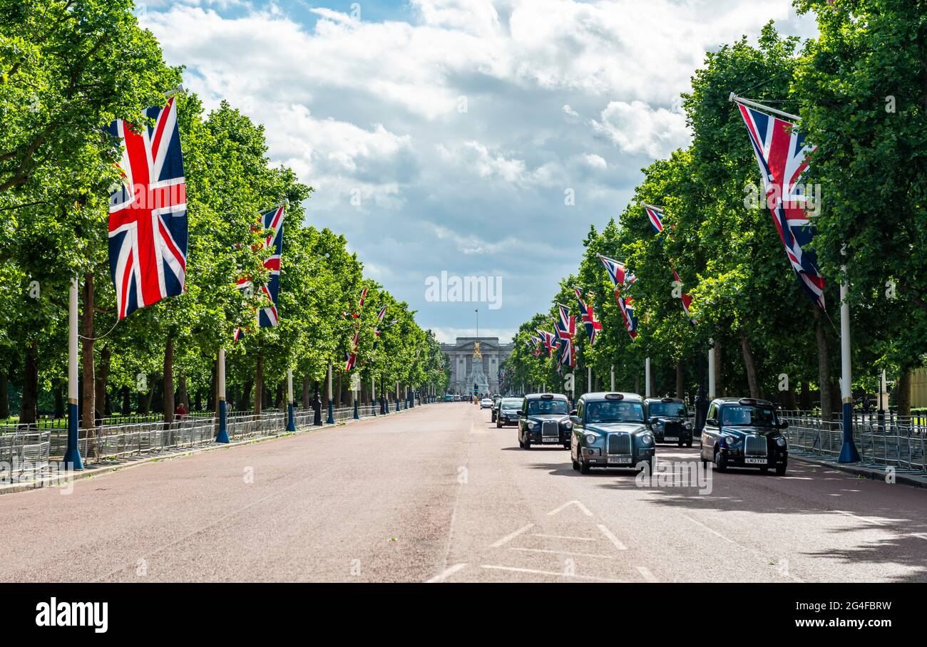 London Taxis auf der Straße The Mall mit aufgereihten britischen Flaggen, hinten Buckingham Palace, City of Westminster, London, England, Großbritannien Stockfoto