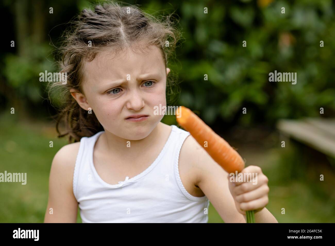 Mädchen mit Karotte dreht ihre Nase hoch Stockfoto