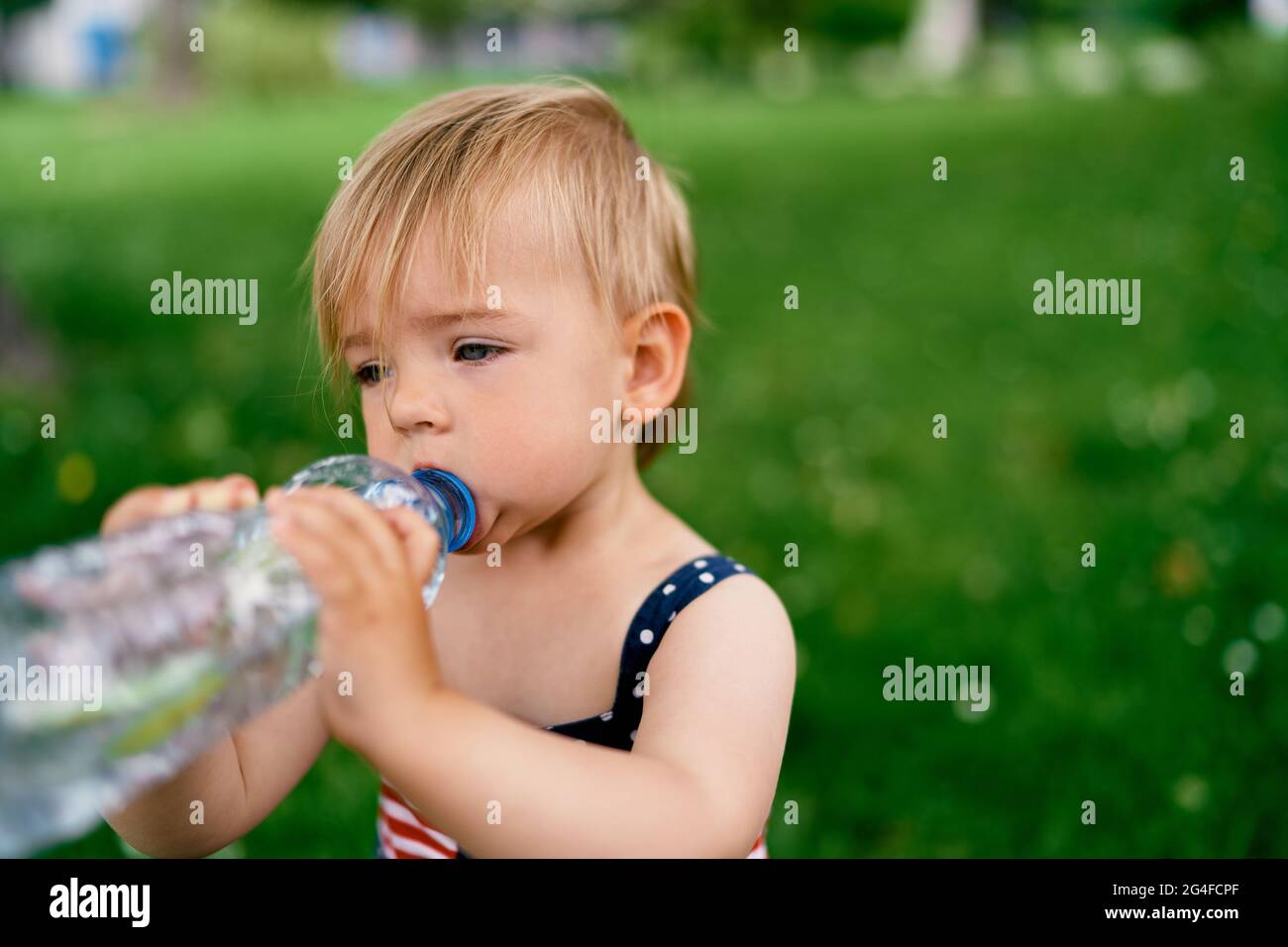 Kleines Mädchen trinkt Wasser aus einer Flasche Stockfoto