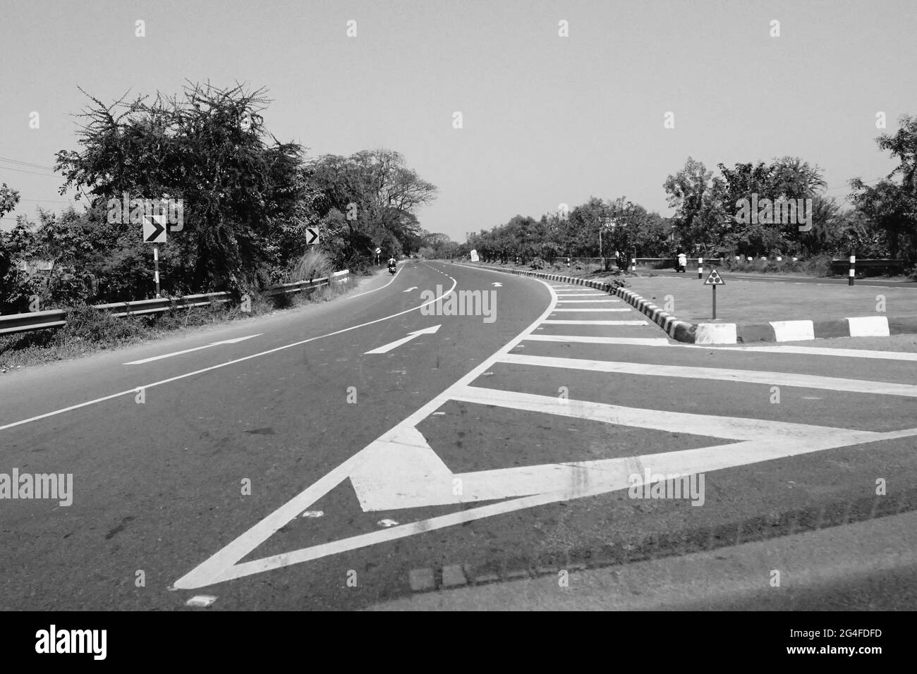 Die weißen Farbmarkierungen auf der indischen Autobahn, Schwarz-Weiß-Aufnahme bei Tag. Stockfoto