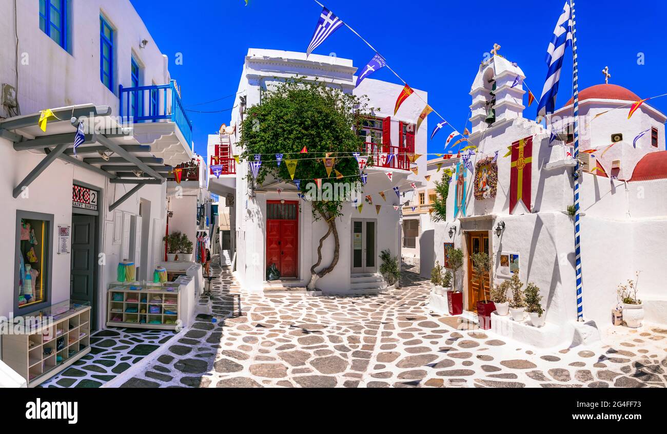 Authentisches traditionelles Griechenland. Charmante bunte Blumenstraßen auf der Insel Mykonos mit Modegeschäften und kleinen Kirchen. Kykladen juni 2021 Stockfoto