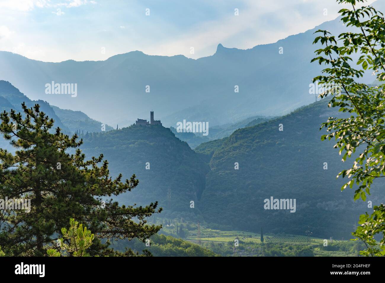 Landschaft mit altem Schloss als Silhoutte an einem nebligen Morgen im Sarca-Tal in der Nähe des Dorfes Dro, in der Nähe des Gardasees, Tentino, Italien Stockfoto