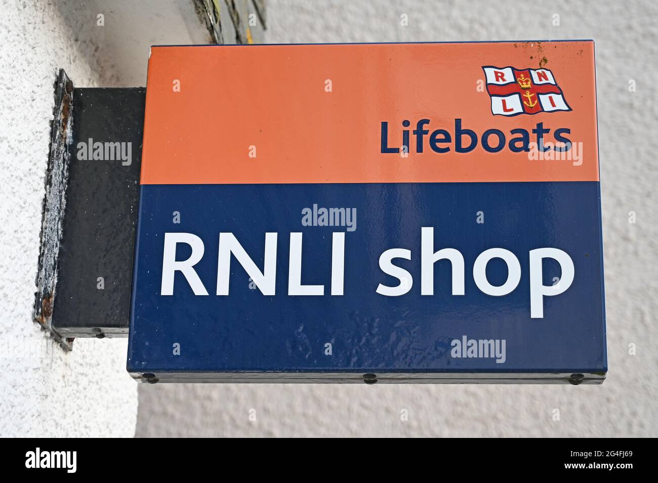 Isoliertes Schild für den RNLI Shop mit verschwommenem weißen Wandhintergrund. Stockfoto