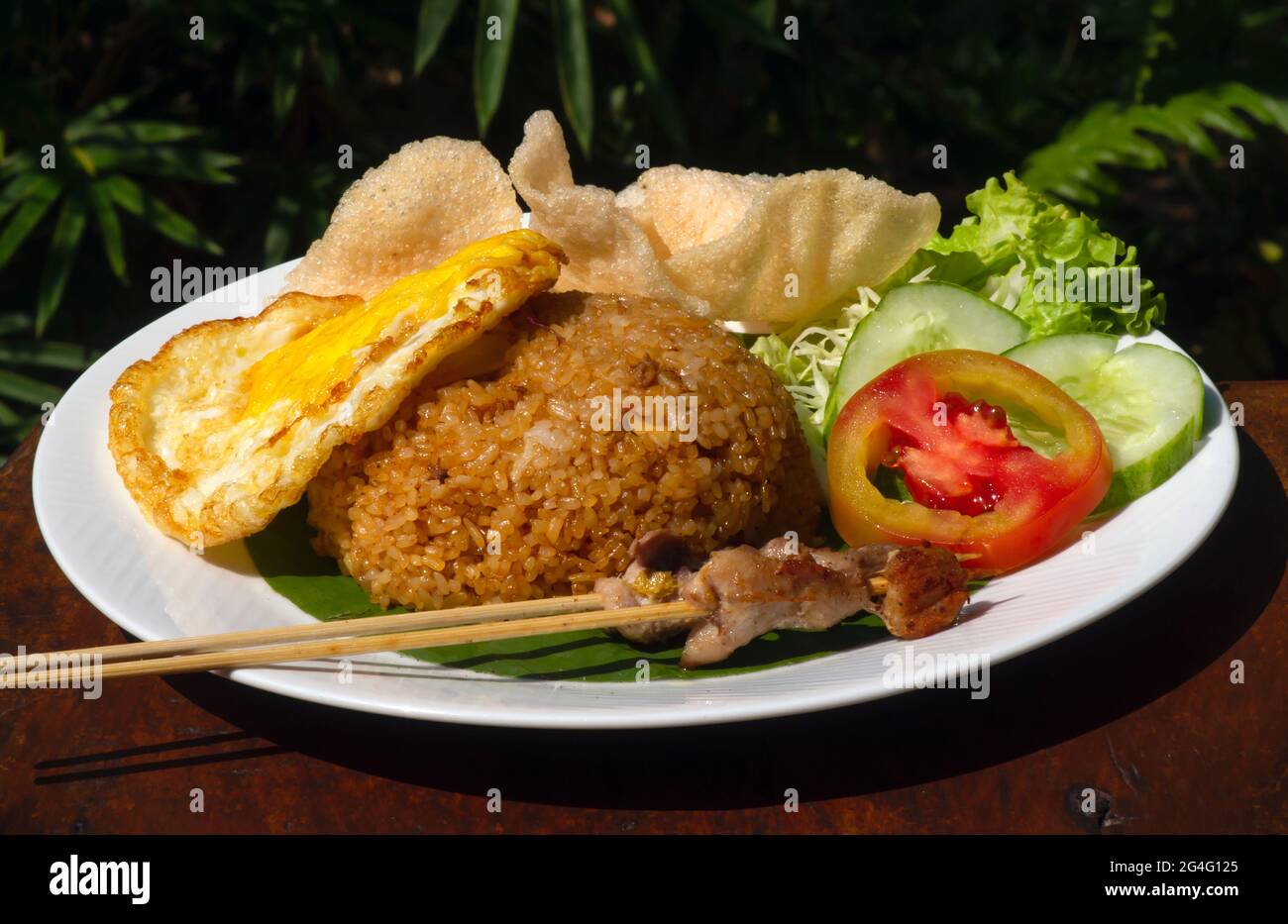 Nasi Goreng, gebratener Reis, traditionelle indonesische Küche, mit Hühnereier und Gemüse auf einem weißen Teller. Indonesische Küche. Stockfoto