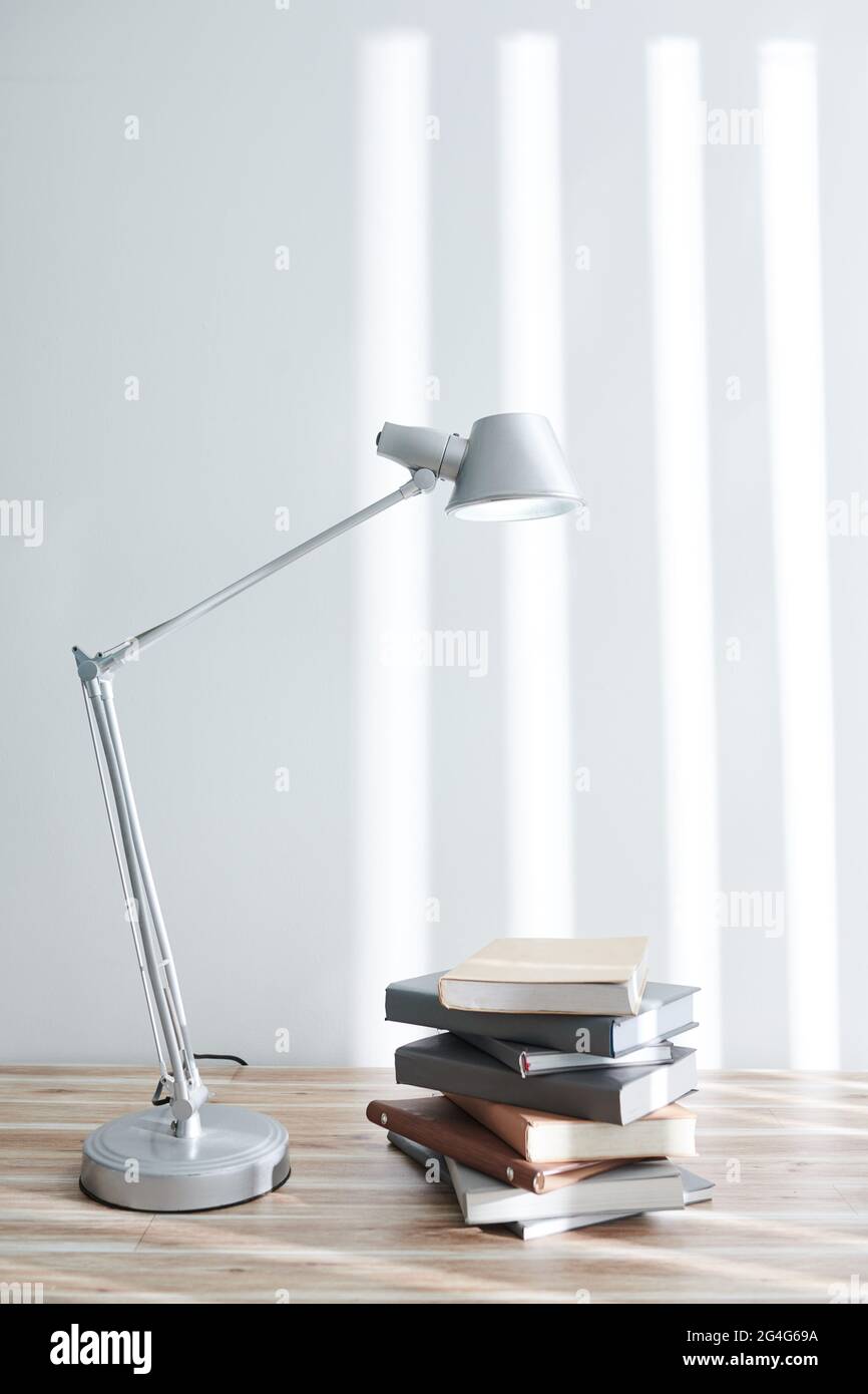 Stapel von Studenten Bücher unter Lampe auf dem Tisch im Home Office, Bildung und Wissenskonzept Stockfoto