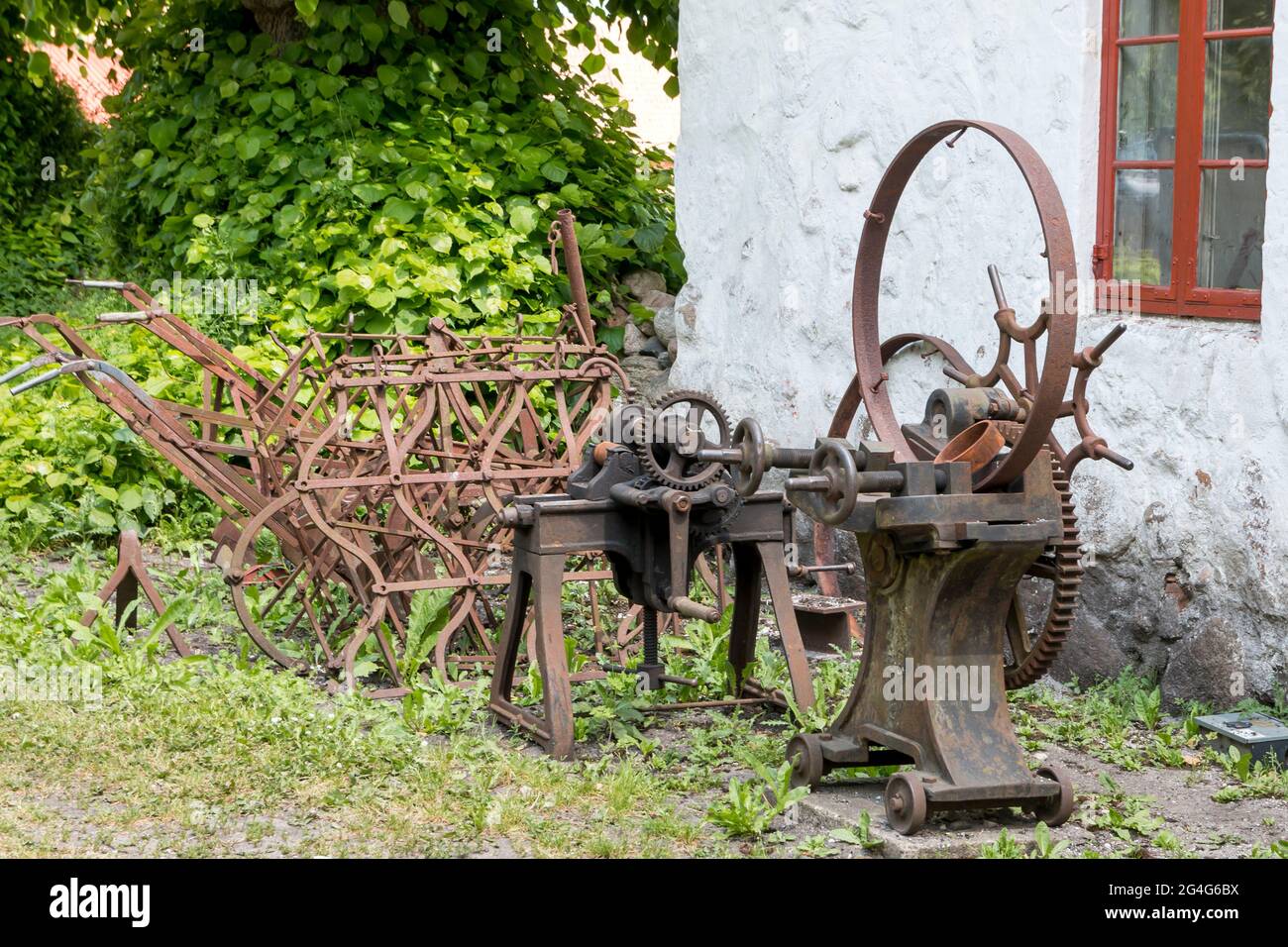 Auning, Dänemark - 19. Juni 2021: Alte Feldgeräte vor einer alten Schmiede Stockfoto