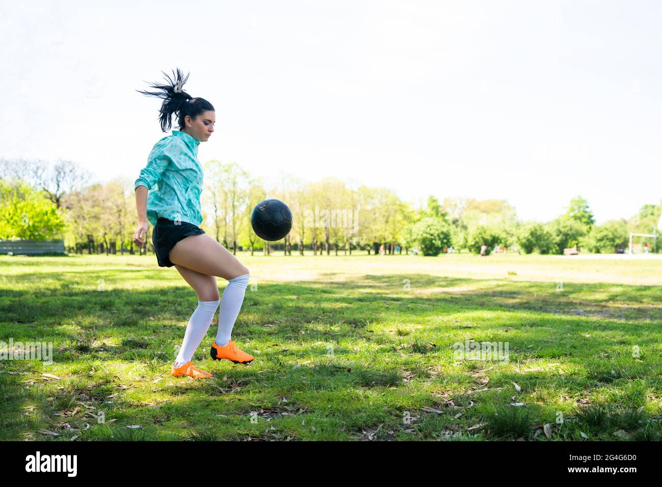 Junge Frau übt Fußball mit Ball. Stockfoto