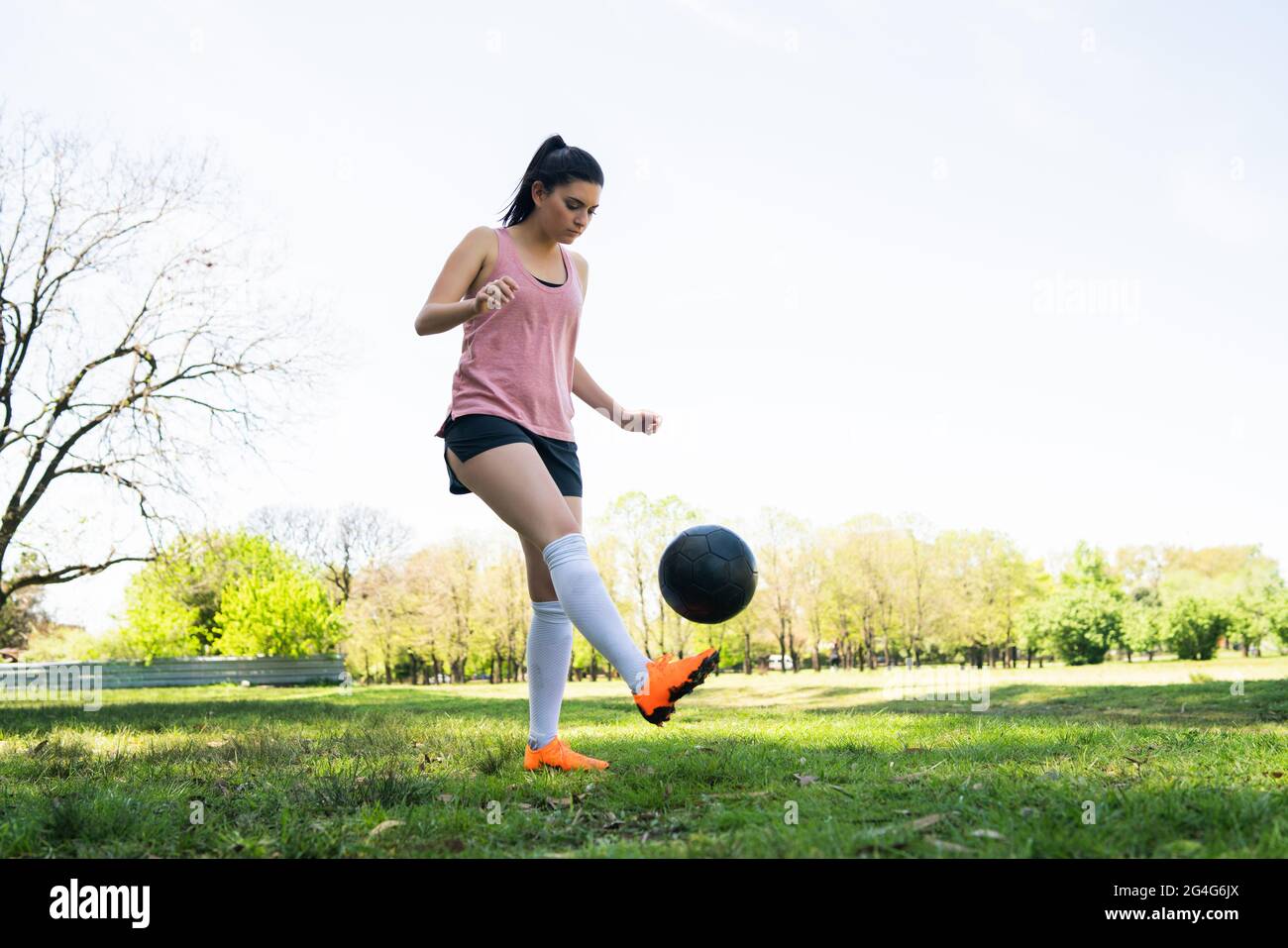 Junge Fußballspielerin übt auf dem Feld. Stockfoto
