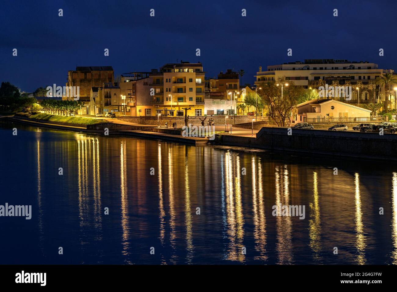 Stadt Amposta, nachts beleuchtet von der Amposta-Brücke (Ebro River, Tarragona, Katalonien, Spanien) ESP: Ciudad de Amposta, de noche, España Stockfoto