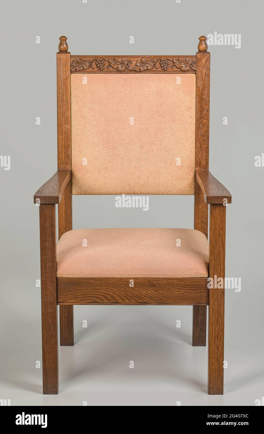 Ein Stuhl mit hoher Rückenlehne und Armlehnen. Der Stuhl hat ein dunkles Holz-Finish. Zwei einfache Finials befinden sich oben auf dem Rücken des Stuhls auf beiden Seiten. Auf der Rückseite des Stuhls
