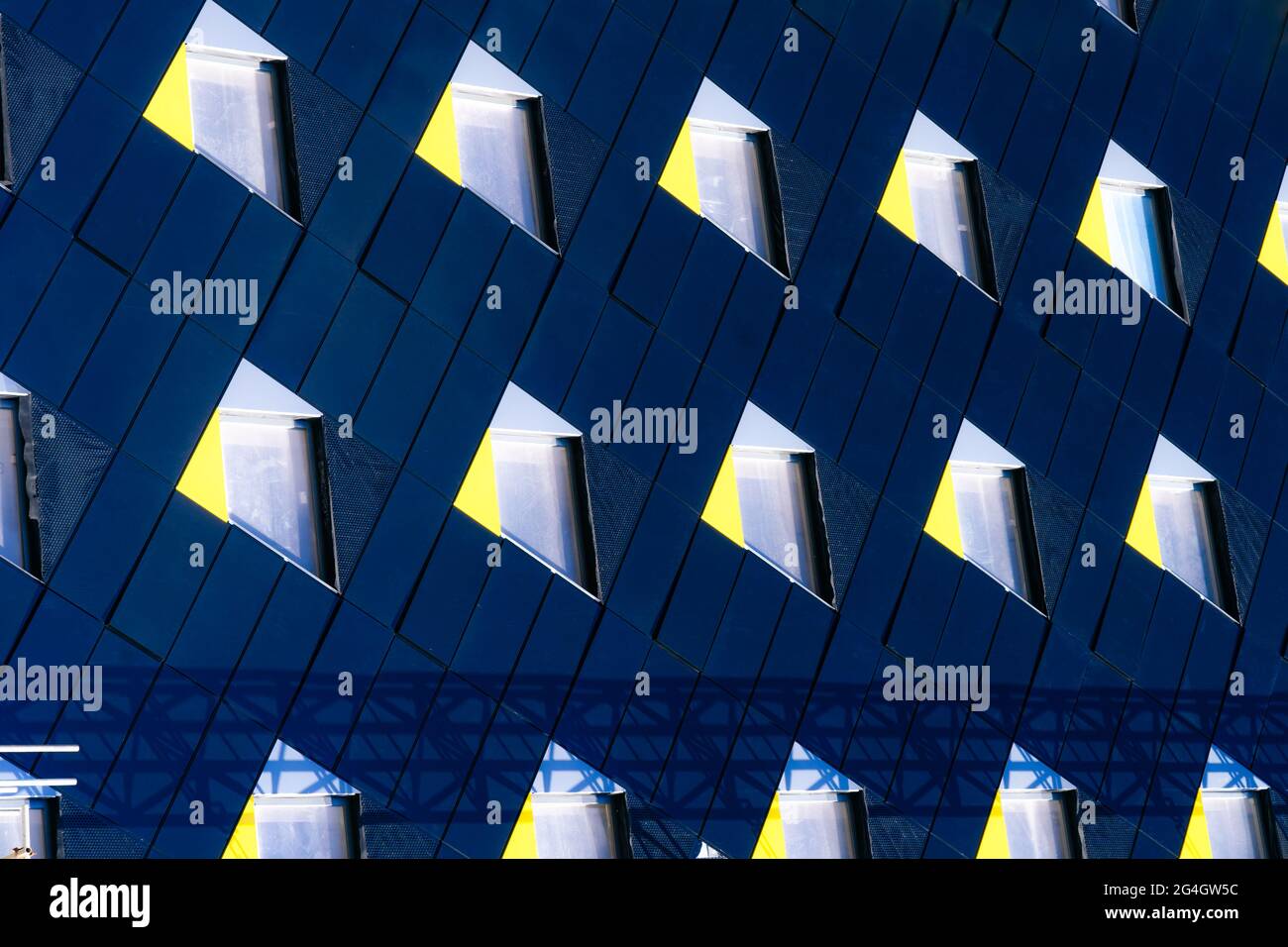 Abstrakter minimaler Architekturhintergrund. Moderne Gebäudefassade Detail. Geometrische dunkle marineblaue Fassade mit Fenstern. Moderne Gebäudefassade Stockfoto
