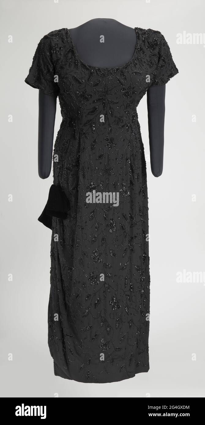 Ella Jane Fitzgerald (1917-1996) war eine afroamerikanische Jazzsängerin, manchmal auch als First Lady of Song, Queen of Jazz und Lady Ella bezeichnet. Das Kleid besteht aus schwarzem synthetischen Kreppstoff, der von Hand mit schwarzen Glassamen und Knabberperlen beperelt wird, und schwarzen Pailletten im Blumenmuster. Das Oberteil ist kurzärmelig und hat einen U-Ausschnitt in der Vorderseite und einen V-Ausschnitt in der Rückseite. In der Mitte des Rückens befindet sich ein Reißverschluss aus Metall, der zur Hüfte führt, und oben am Reißverschluss befindet sich ein Haken-und-Öse. Das Kleid hat eine Prinzessin geschnitten Taille, aber es gibt keine Naht an der Taille. Das Kleid hat eine Spalte Rock w Stockfoto