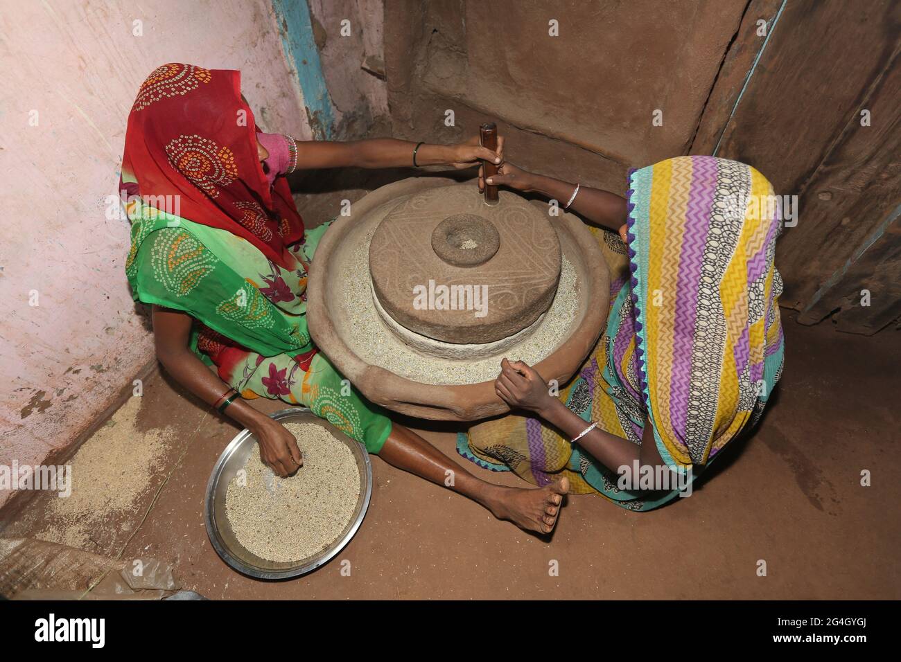 DHANKA TADVI STAMM. Zwei Frauen, die im Dorf Mogarapani - Akkalkuwa tehsil - Nandurbar Dist - Maharashtra an einer traditionellen Maschine schleifen Stockfoto