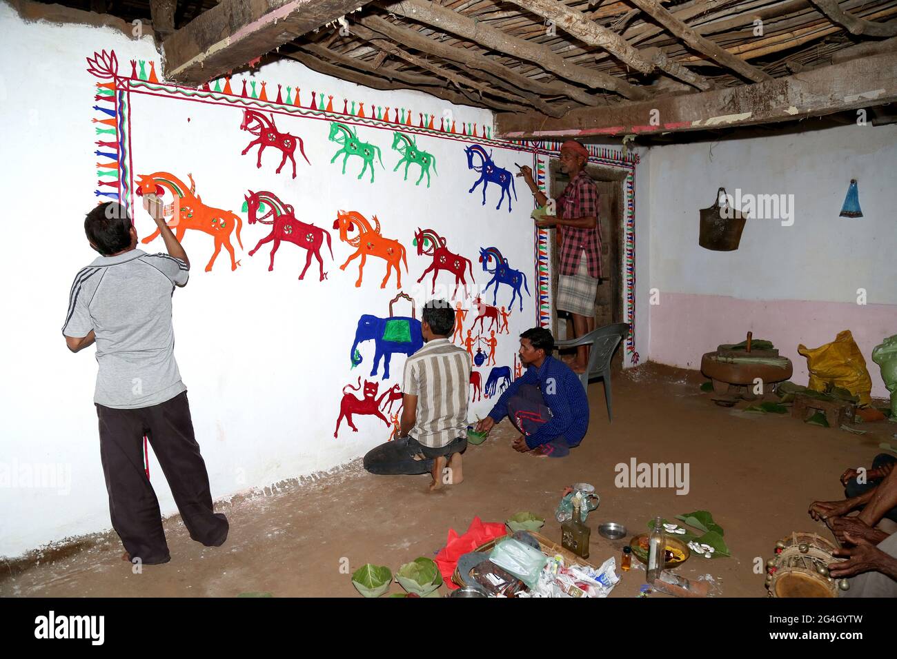 RATHAWA TRIBAL-Künstler zeichnen Pithora-Gemälde auf einer Lehmwand in einem Haus. Pithora Gemälde sind hoch angereichert Volkskunstkultur von Gujarat Stockfoto