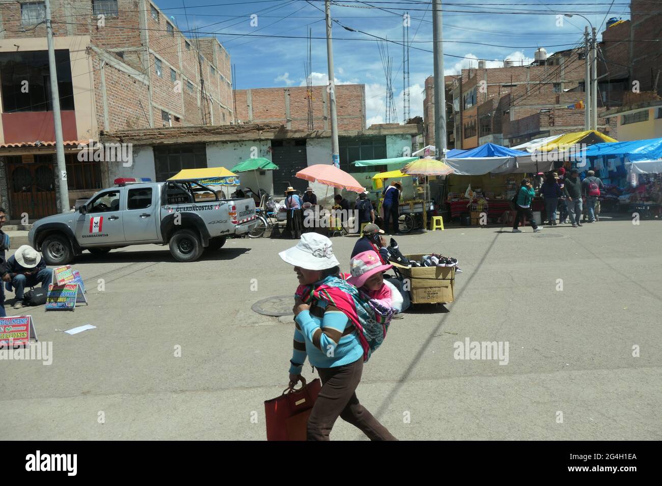 Eine Dame aus Cuzco, die mit ihrem Baby auf dem Rücken in Peru unterwegs ist Stockfoto