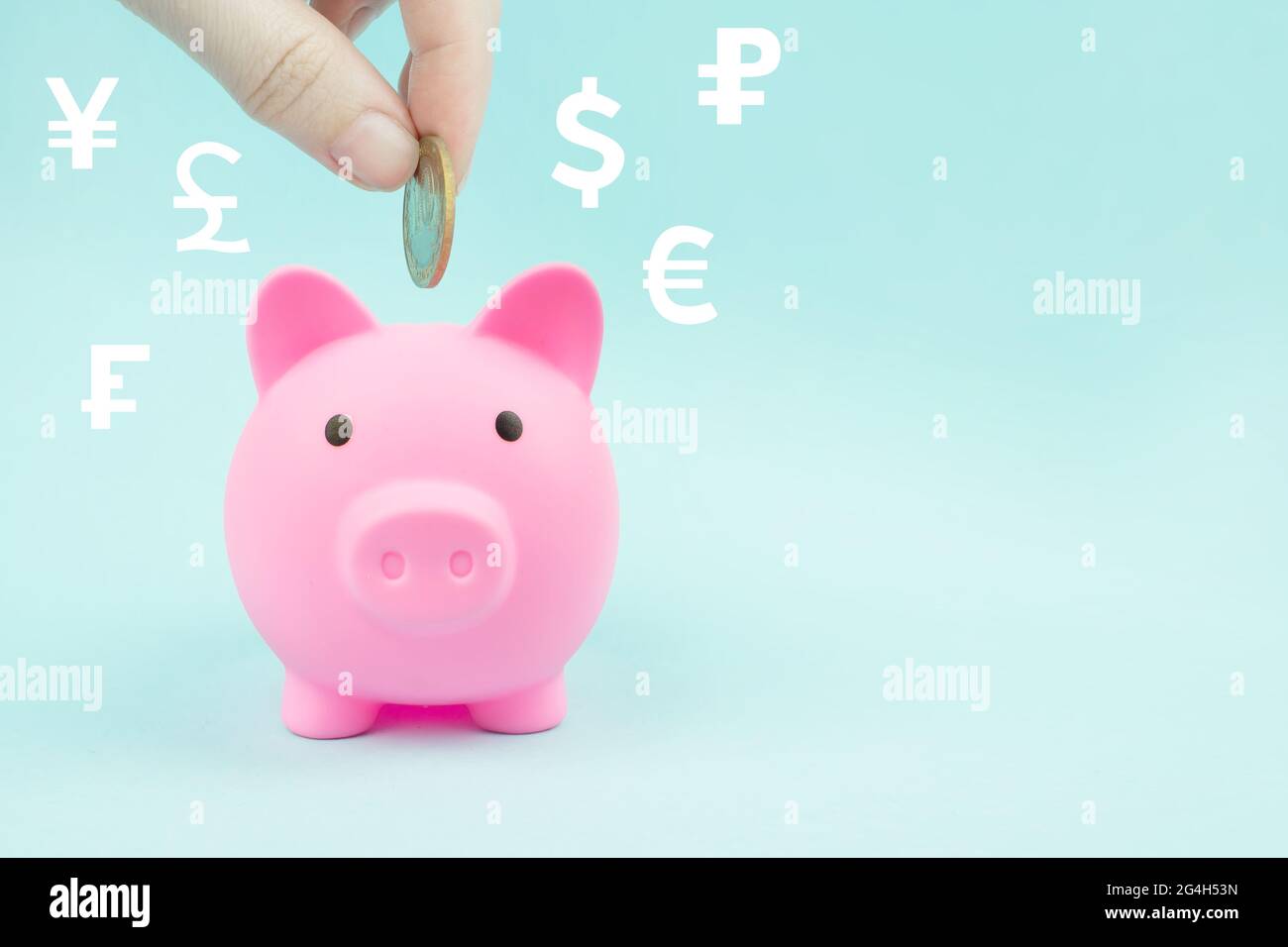 Hand, die eine Münze in Sparschwein mit digitalen Hologramm-Weltwährungen auf blauem Hintergrund. Finanzielle Ersparnisse und die Bankenwirtschaft Stockfoto
