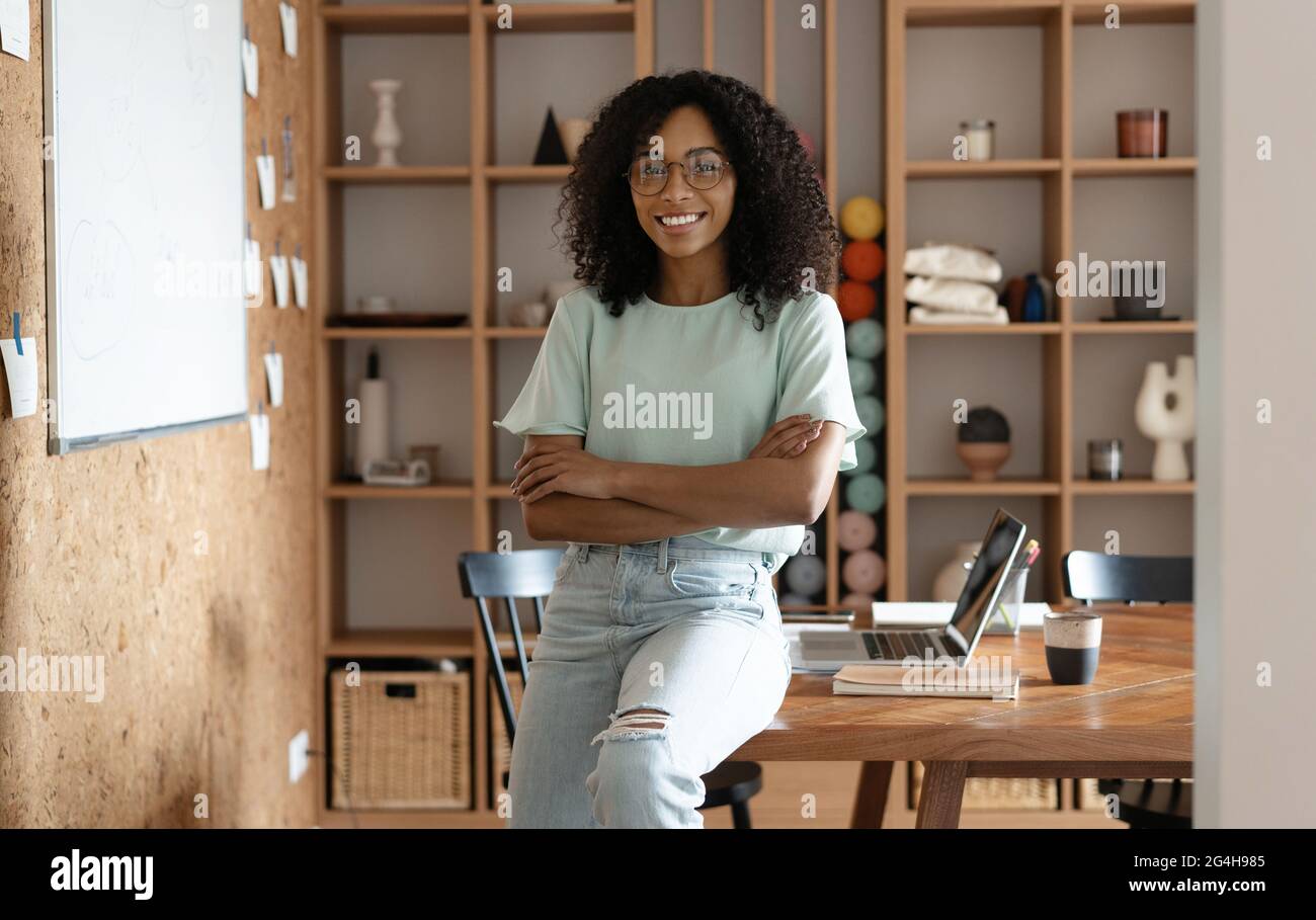 Porträt einer glücklichen, lächelnden Geschäftsfrau mit gemischter Rasse in ihrem Büro. Stockfoto