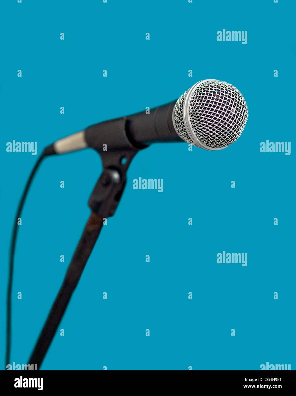 Standmikrofon mit hellblauem Hintergrund mit selektivem Fokus- und Kopierbereich, vertikal Stockfoto