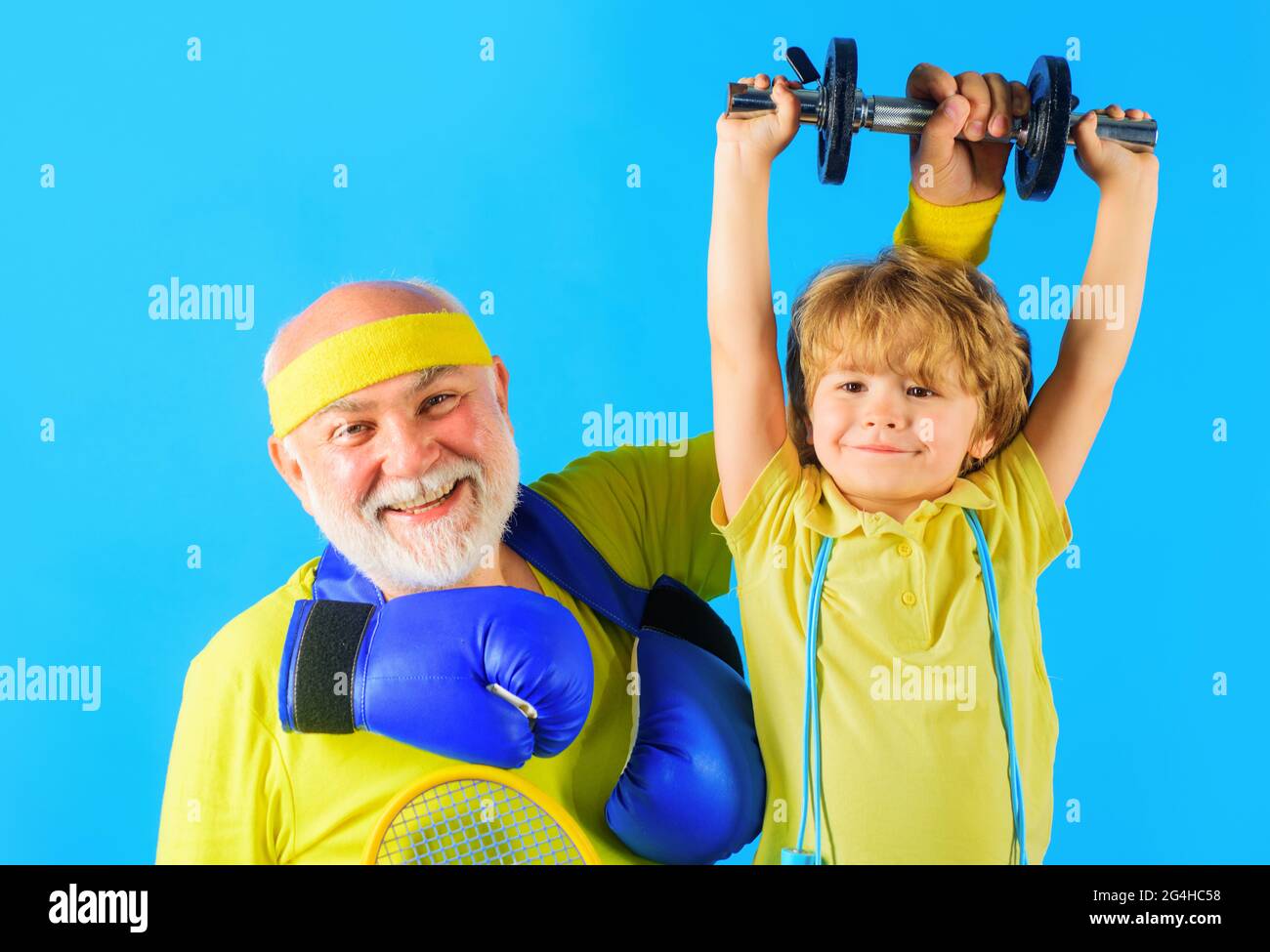 Familiensport. Opa und Sohn trainieren gemeinsam. Kind Junge Hantel heben. Großvater und Kind sportlich. Stockfoto