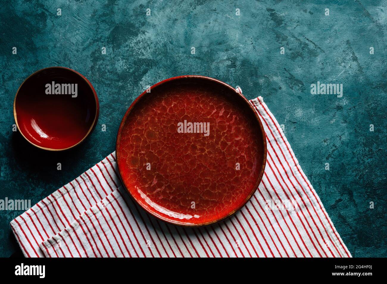 Küche Hintergrund. Rote Keramikplatte auf blauem Hintergrund. Kopierraum Stockfoto