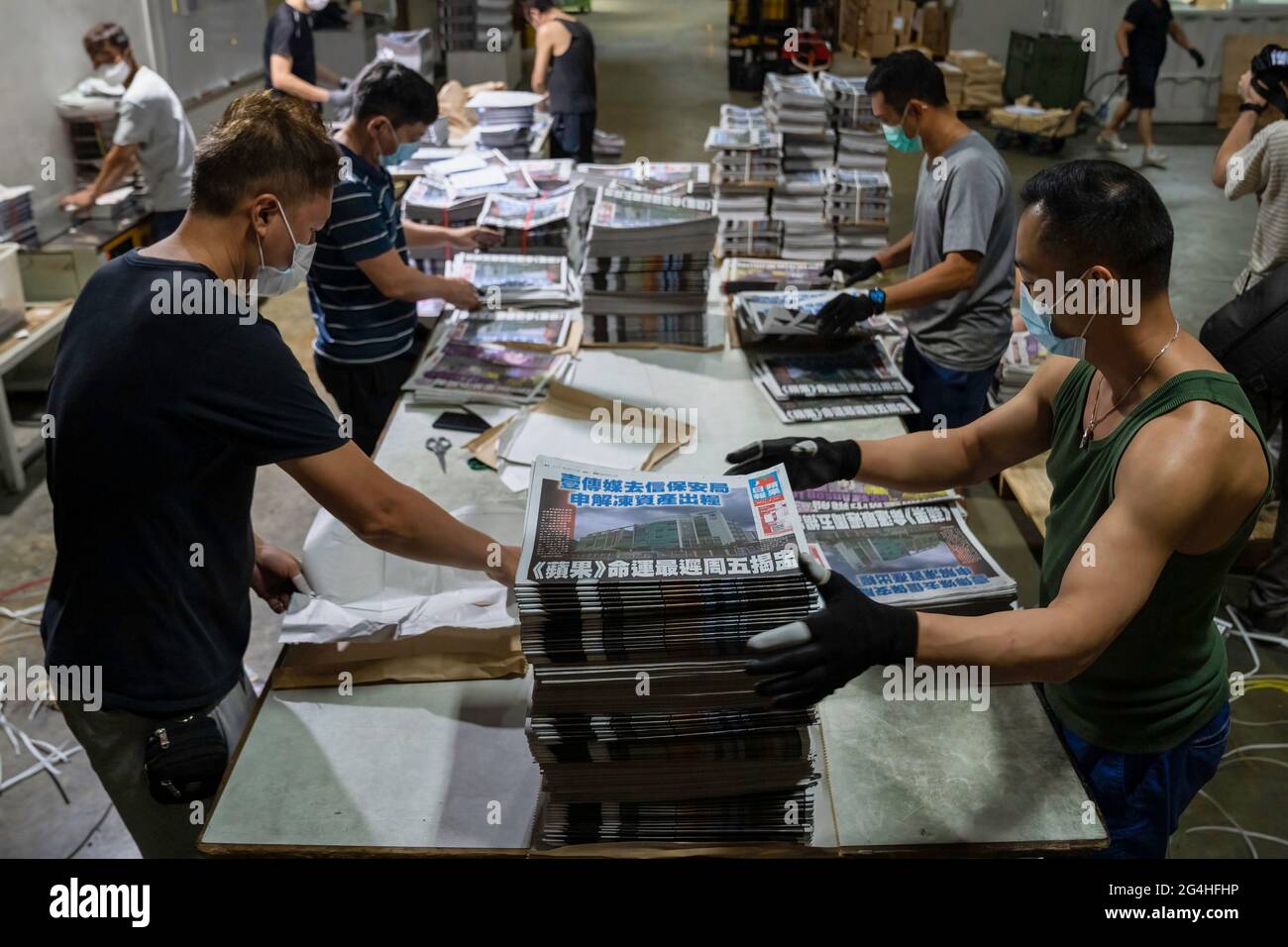 Hongkong, China. Juni 2021. In der Druckerei der Zeitungsbüros der Apple Daily in Hongkong stellen Mitarbeiter Teile frisch gedruckter Papiere zusammen.die prodemokratische Zeitung Apple Daily in Hongkong hat angekündigt, dass sie ihren Betrieb bis Ende der Woche einstellen wird, nachdem die Behörden ein durchschlagenes nationales Sicherheitsgesetz zum Einfrieren des verwendet haben Die Vermögenswerte des Unternehmens zu verhaften und führende Redakteure und Führungskräfte zu verhaften. Kredit: SOPA Images Limited/Alamy Live Nachrichten Stockfoto