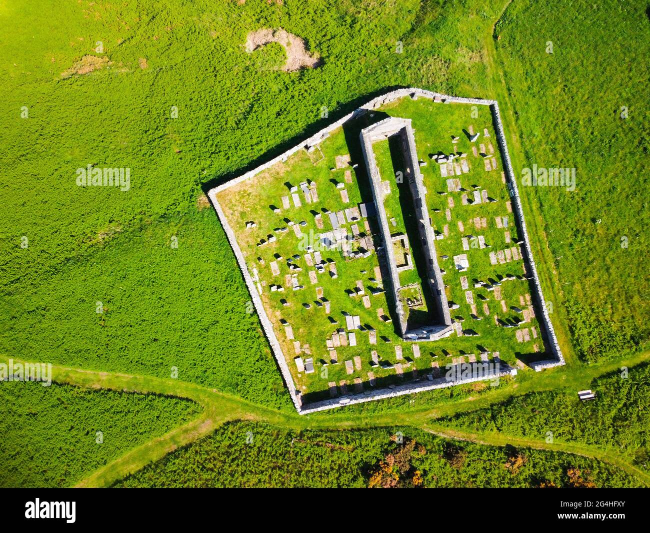 Luftaufnahme von der Drohne der St John’s Church und Kirkyard mit Blick auf das Dorf Gardenstown an der Moray firth Coast in Aberdeenshire, Schottland, Großbritannien Stockfoto