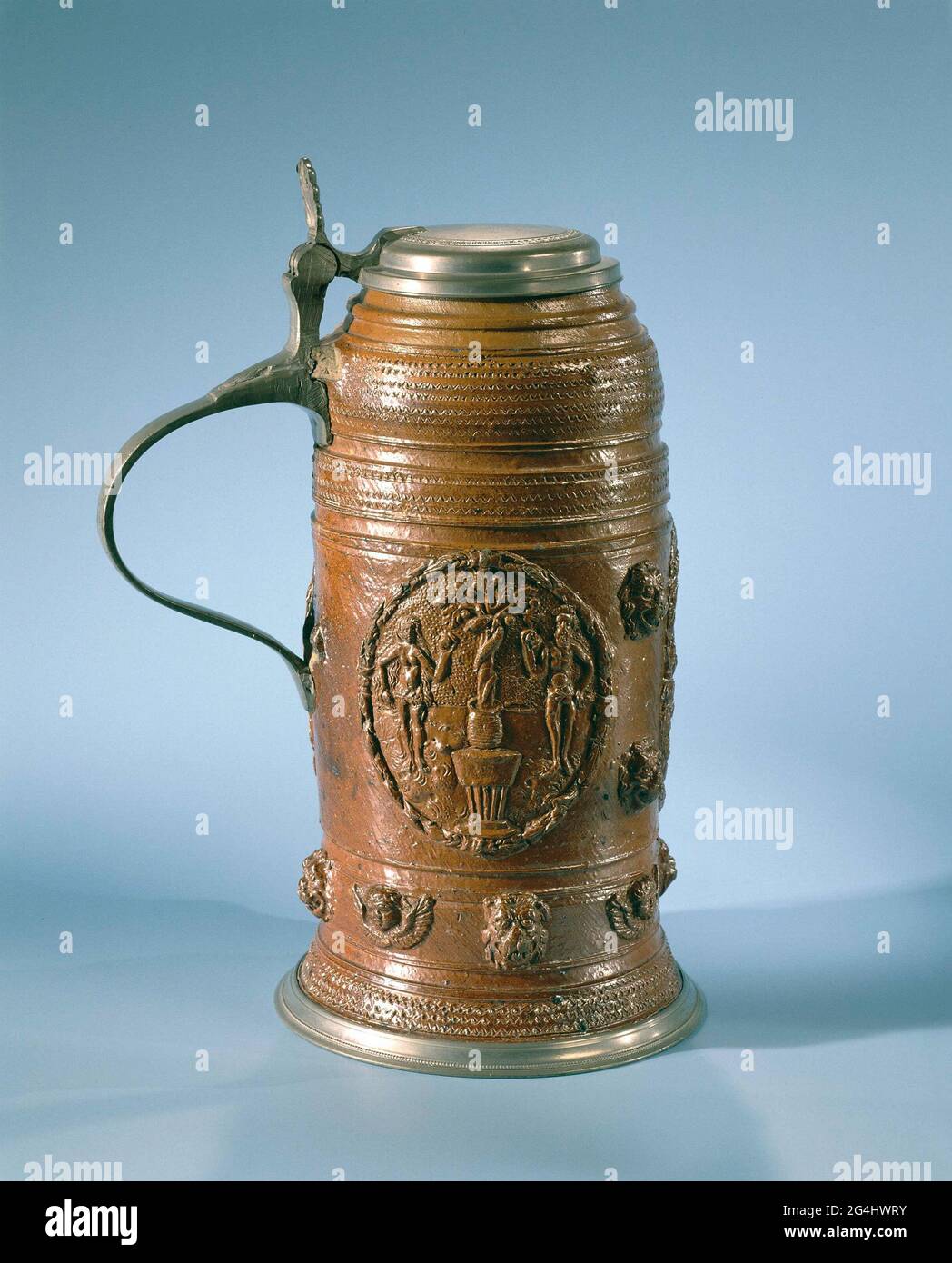 . Großer brauner Bierkrug mit Zinndeckel. Dekoriert mit drei Medaillons mit Waffen und Monogramm D.I.H., weiter verziert mit Adam und Eva und Löwen und Engelsköpfen. Stockfoto