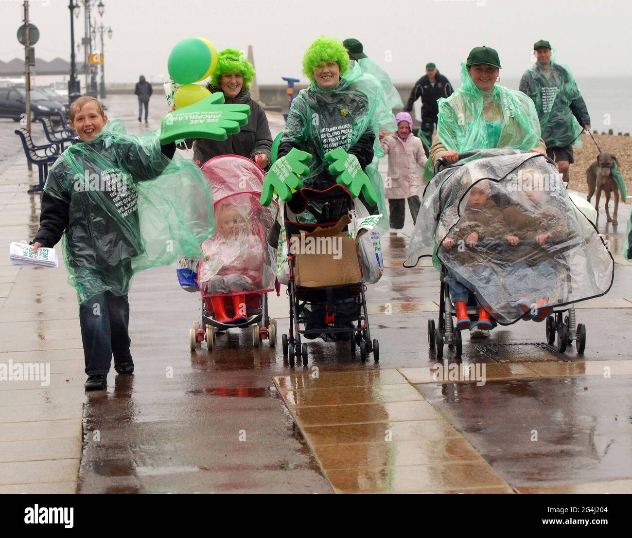 AUSGEWASCHEN. JUGENDLICHE UND IHRE MÜTTER KÄMPFEN AUF IHREM WOHLTÄTIGKEITSSPAZIERGANG FÜR DEN KREBSVERBAND MACMILLAN GEGEN DIE ELEMENTE AN DER KÜSTE VON SOUTHSEA IN HAMPSHIRE. PIC MIKE WALKER, 2008 Stockfoto