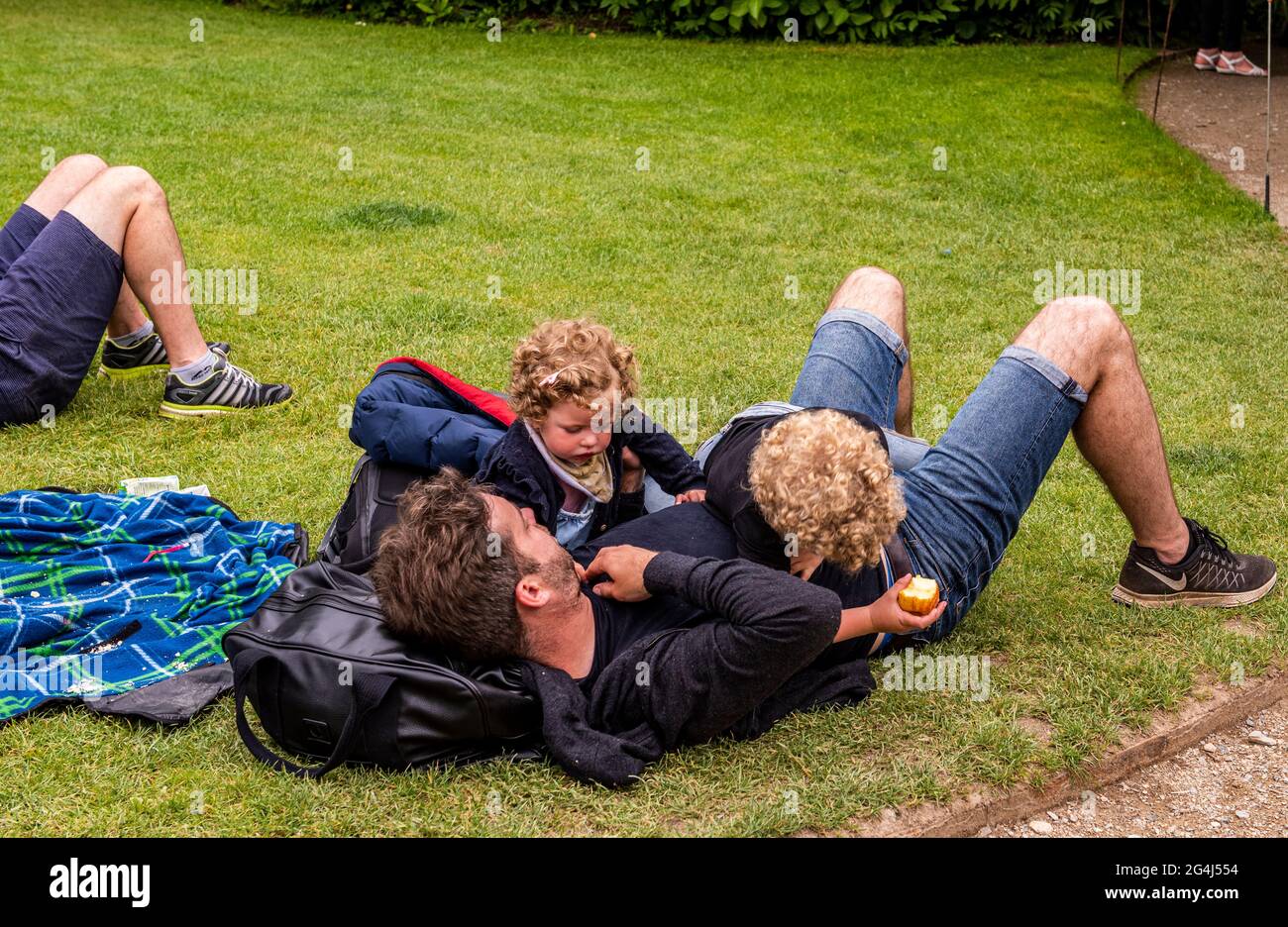 Vater und Kinder liegen auf Gras, Lost Gardens of Heligan, Cornwall Stockfoto
