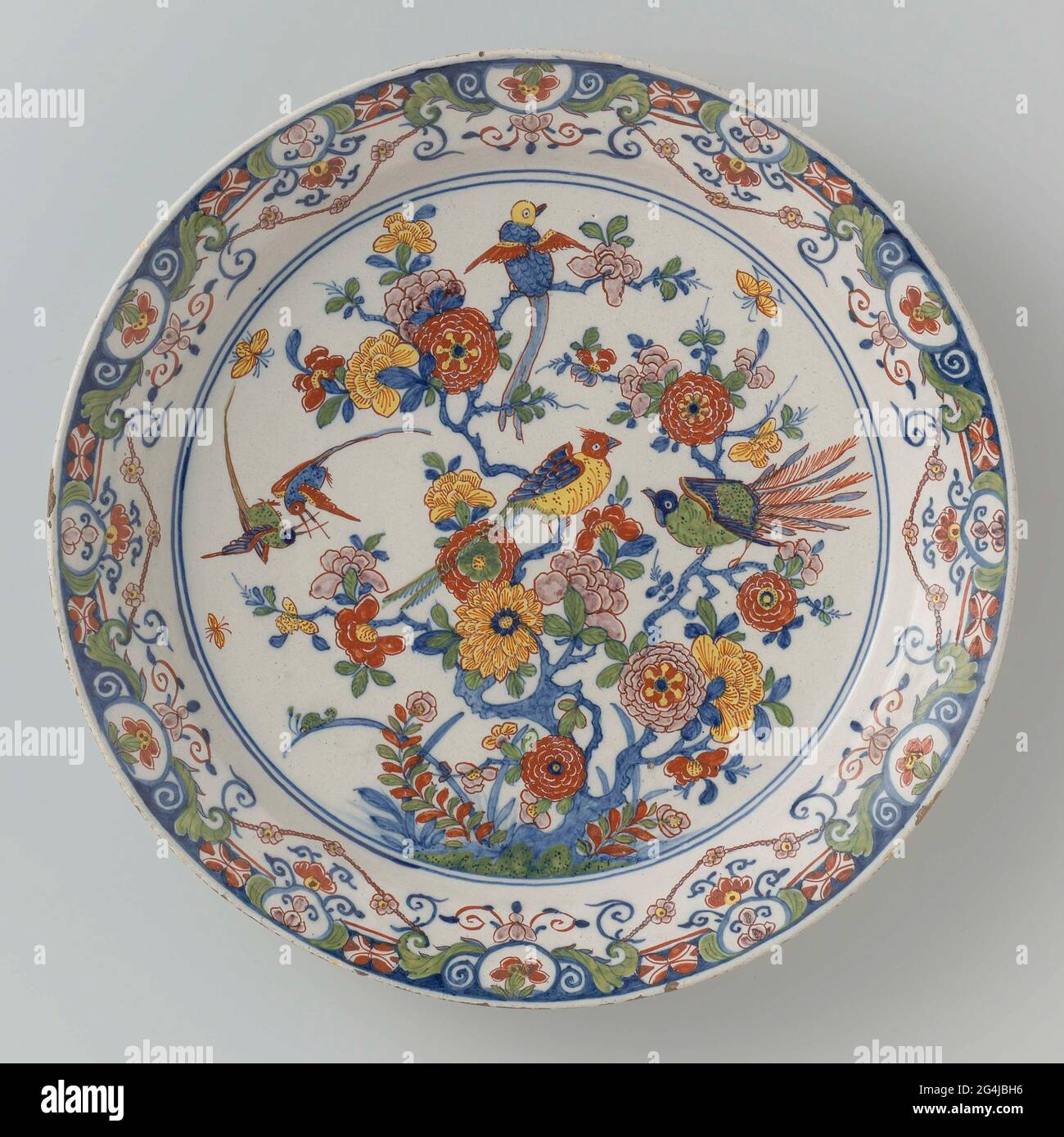 . Schale von Faïence, mehrfarbig mit Chinoiserie bemalt: Auf der Wohnung eine Blume mit Vögeln. Kante der Lammrequine. Stockfoto