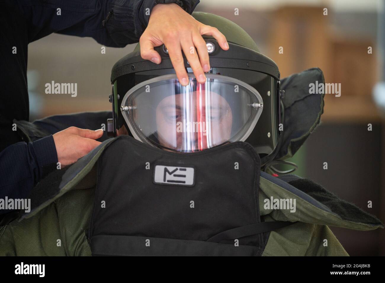 Stuttgart, Deutschland. Juni 2021. Ein entschärfender Offizier wird von einem Kollegen bei einer Demonstration einer Übung des Landeskriminalamtes Baden-Württemberg mit einer Bombenschutzklage angeworfen. (To dpa: 'Defusers of the LKA - Manchmal sprengen sie sich selbst') Quelle: Marijan Murat/dpa/Alamy Live News Stockfoto