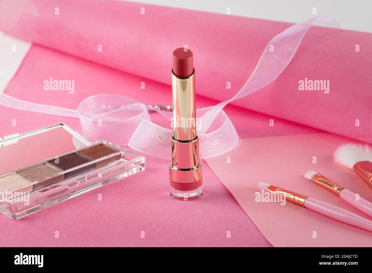 Schönes Stillleben von Kosmetika, Accessoires und Schmuck auf einem rosa Hintergrund. Stockfoto