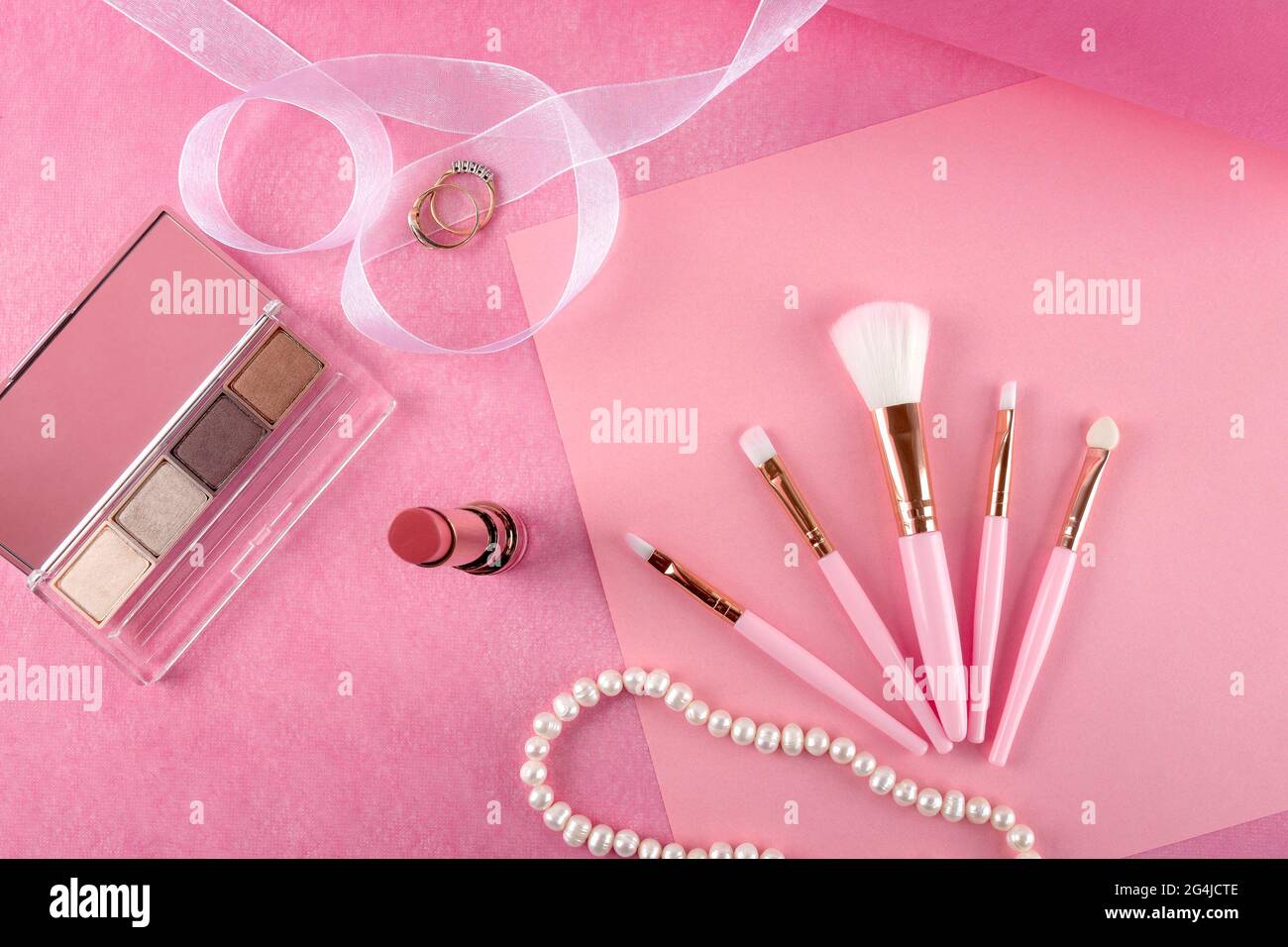 Schönes Stillleben von Kosmetika, Accessoires und Schmuck auf einem rosa Hintergrund. Stockfoto