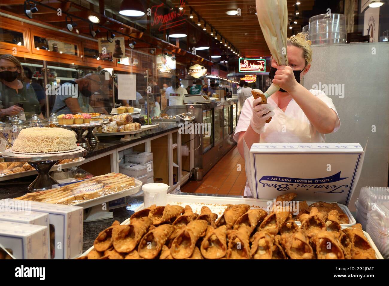 Ein Bäcker bereitet in der Bäckerei Termini Brothers im Reading Terminal Market, Philadelphia, Pennsylvania, eine Schachtel mit handgefüllten Kanülen zu Stockfoto