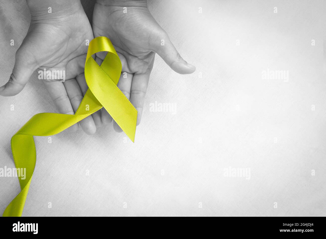 Hände halten hellgrün Band auf weißem Stoff Hintergrund mit Kopierer Platz. Welttag der psychischen Gesundheit und Lymphom Bewusstsein Symbol. Gesundheitswesen ME Stockfoto