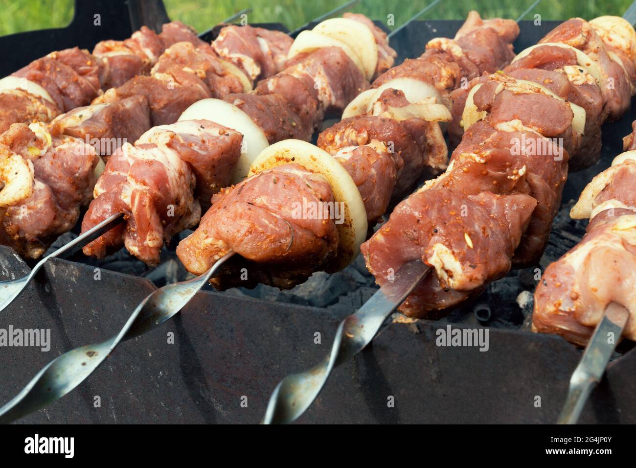 Marinierte schaschlik Vorbereitung auf einem Grill über Kohle. Schaschlik oder Shish Kebab populär in Osteuropa. (Shashlyk aufgespießt Fleisch) war Ursprung Stockfoto