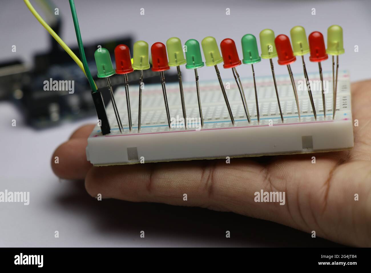 Serie von Leuchtdioden verbinden sich mit der in der Hand gehaltenen Stecktafel, die das Laborkonzept des Erfinders zeigt Stockfoto