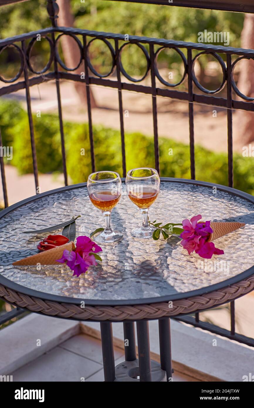 Sommer hausgemachte Cocktails mit rosa Blüten von Bougainvillea auf Glastisch. Haben Sie einen Rest kreativen Konzept. Sommer hell surreale Blumen und erfrischend Stockfoto