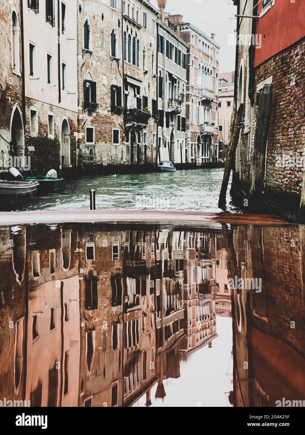 Häuser Reflexionen auf der lackierten Holzhaube, Ponton, des Wassertaxis in den Straßen von Venedig, die abfährt Stockfoto