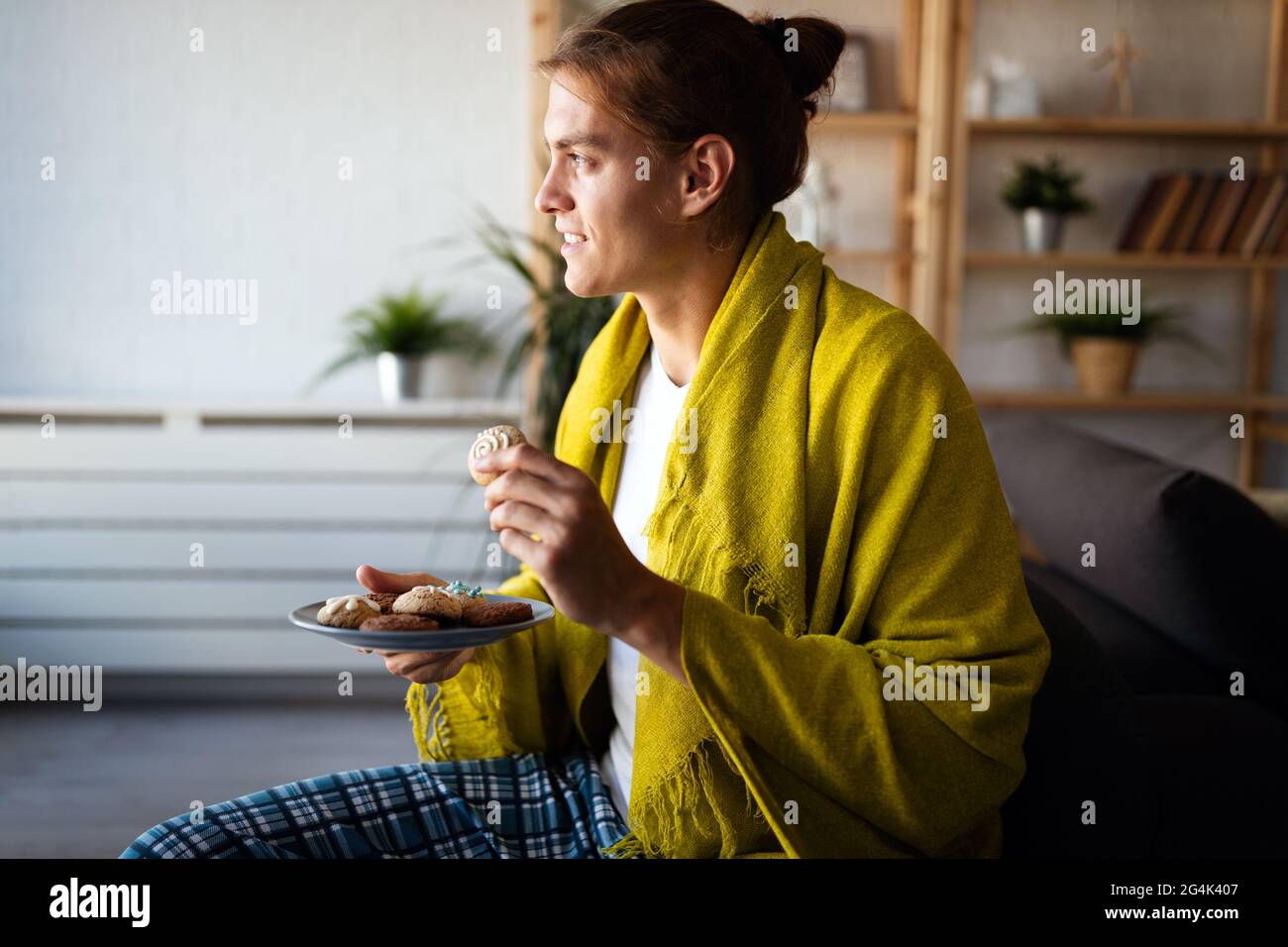 Junger Mann, der sich zu Hause entspannt. Friedliche Erholung zu Hause am Morgen Stockfoto