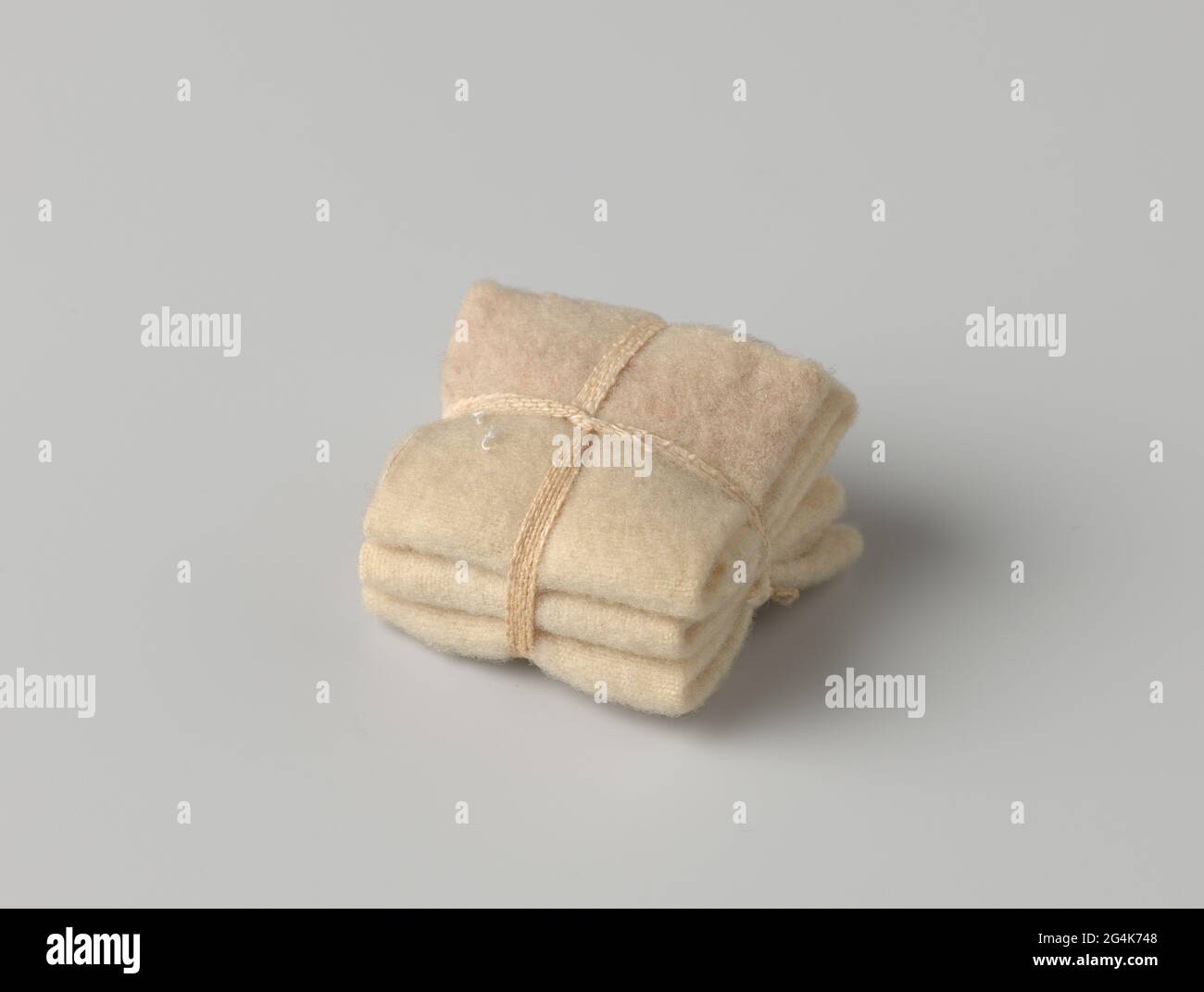 Stapel von Decken, gebunden mit einem Band. Ein Stapel von drei gefalteten und zusammengebundenen Wolldecken (?) Gebündelt mit Leinenband. Stockfoto