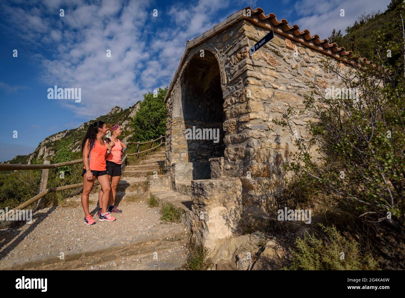 Wanderer wandern von Berga zum Queralt-Heiligtum entlang des Pfades Camí de la Solana. Kapelle von Sant Jacint (Berguedà, Katalonien, Spanien, Pyrenäen) Stockfoto