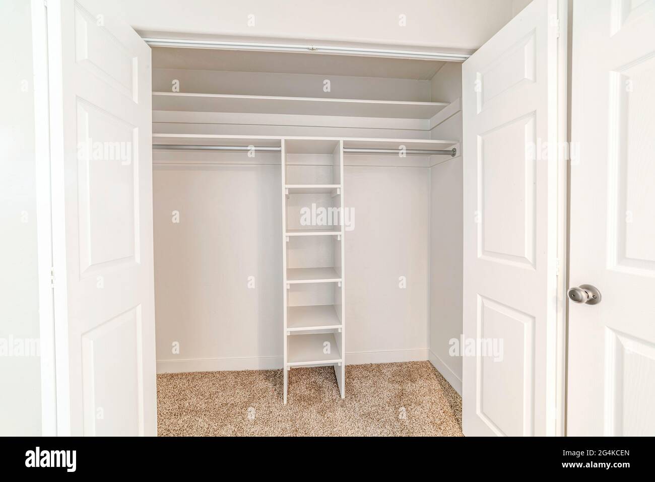 Weißes Zimmer mit Treppe und langem horizontalen Regal Stockfoto