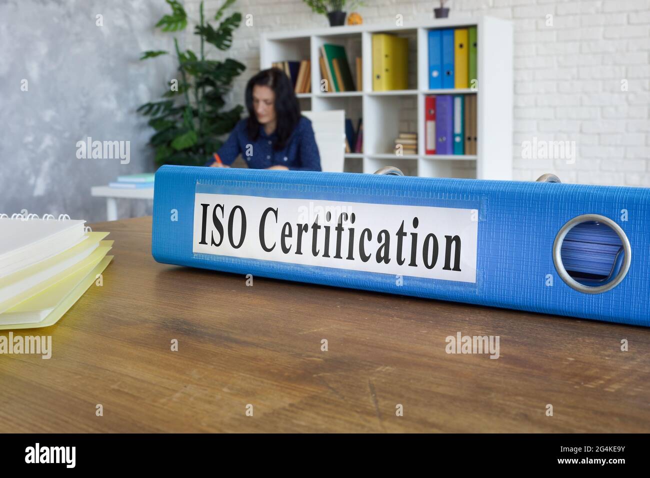 Ordner mit Leitfaden zur ISO-Zertifizierung auf dem Tisch. Stockfoto