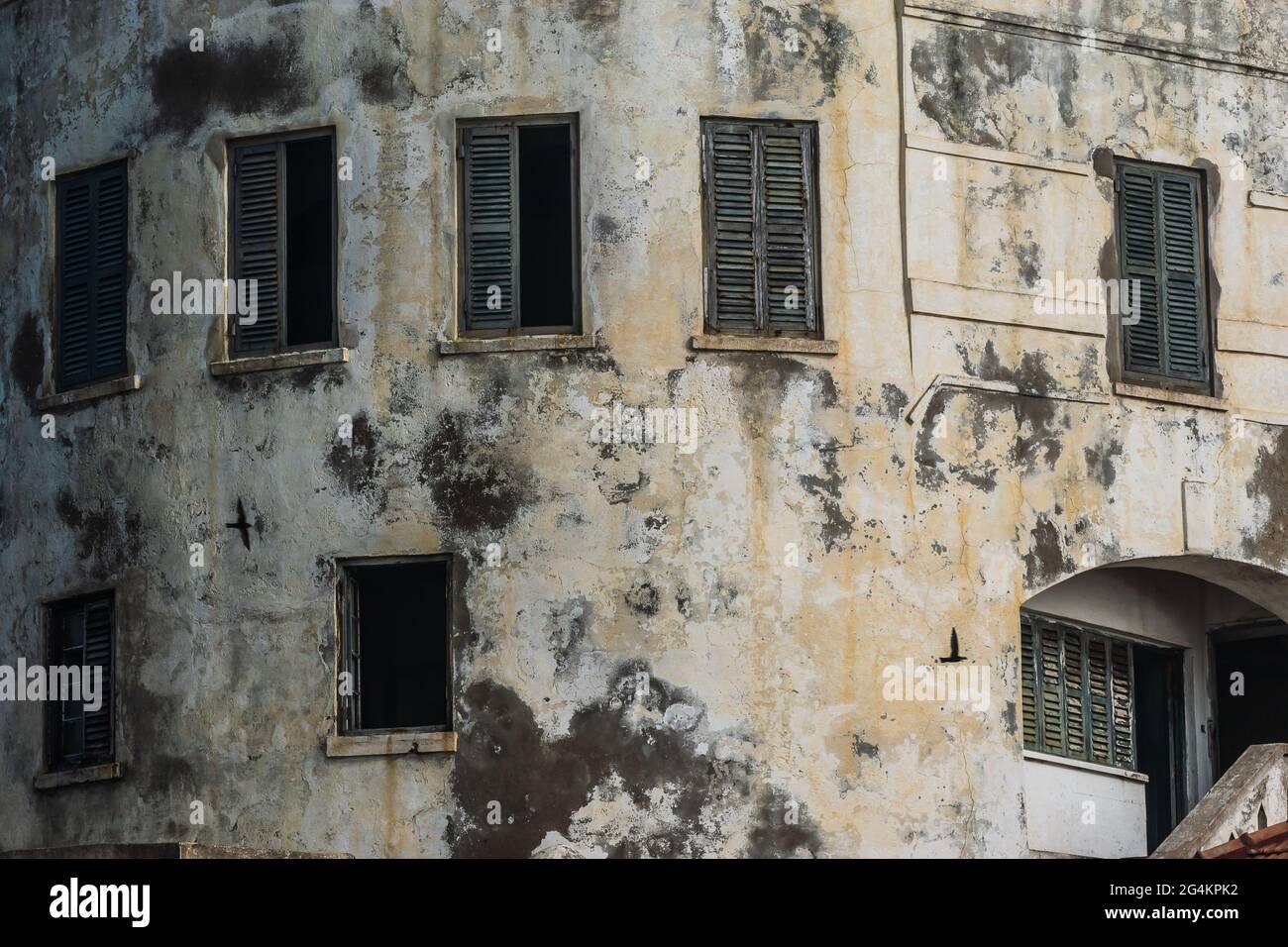 Teil eines Gebäudes in Afrika Ghana und Schatten an der Wand von zwei vorbeiziehenden Vögeln. Cape Coast Castle ist eines von etwa vierzig Sklavenburgen, das im Jahr 2 abgebildet wurde Stockfoto