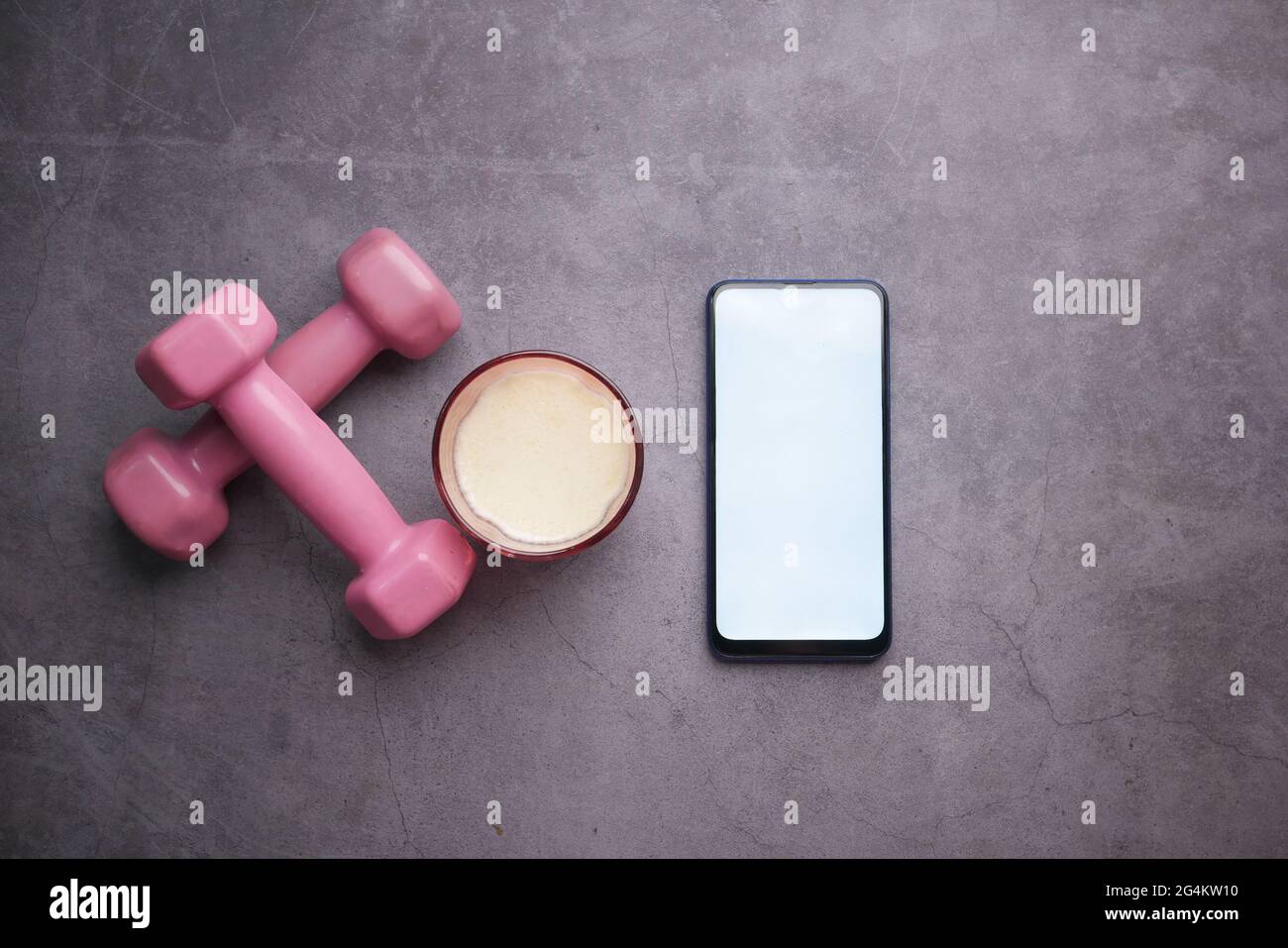 Smartphone mit Sportausrüstung auf schwarzem Hintergrund. Stockfoto