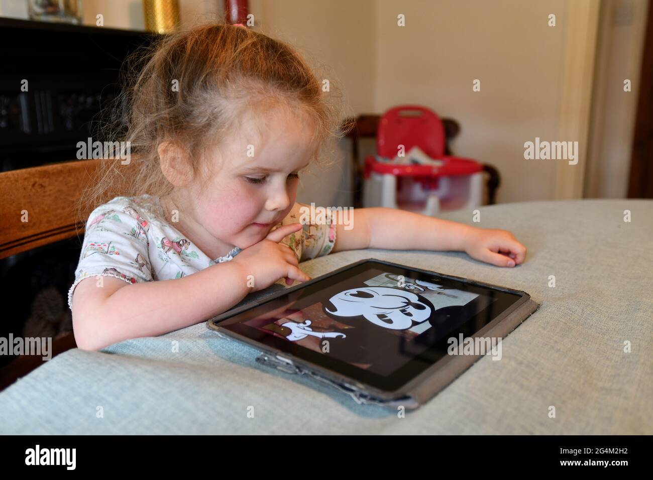 Kind Mädchen beobachten Video auf Apple iPad Tablet zu Hause. Tablet Computer Computer Kinder Kleinkind junge digitale elektronische Geräte Bildschirm Großbritannien Stockfoto